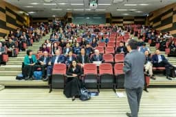 Auditorio lleno de asistentes escuchando a un ponente en un evento