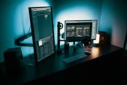 Escritorio en penumbra con un monitor que muestra una aplicación
