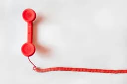 Auricular de teléfono rojo sobre fondo blanco