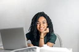 Mujer sonriendo frente a un portátil